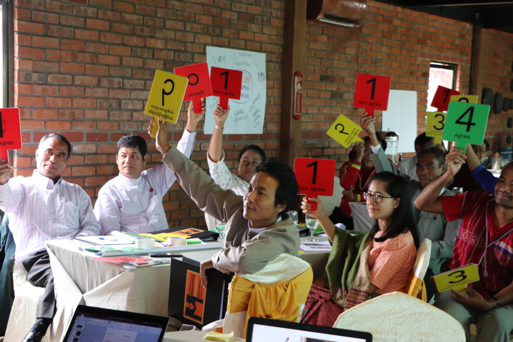 Politicians in a training holding papers with different colors