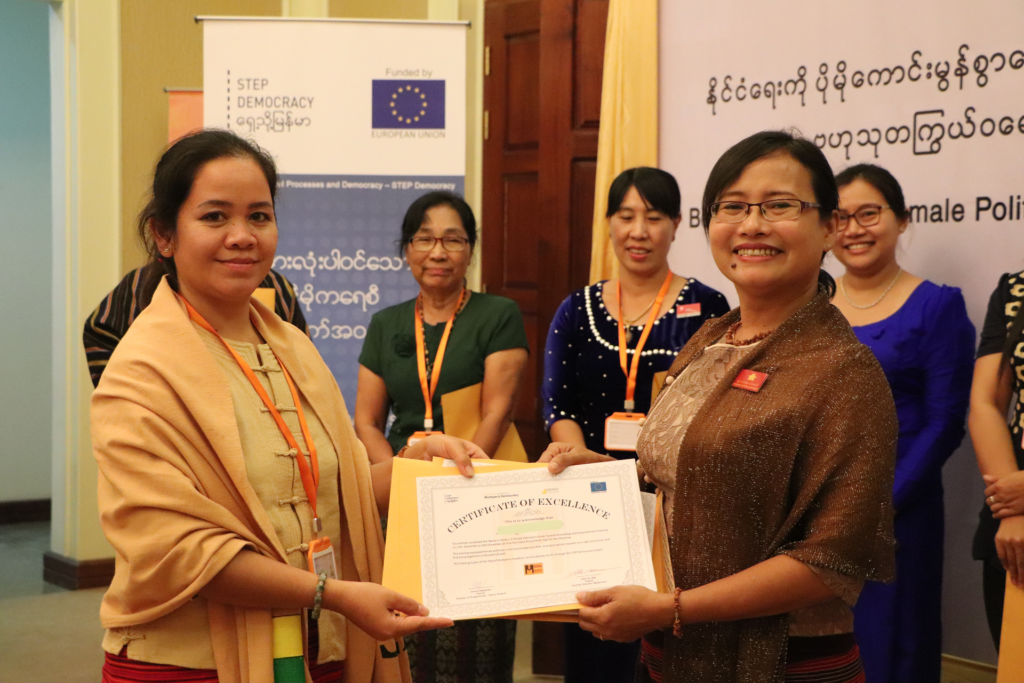 Female politicians in Myanmar showing their training certification