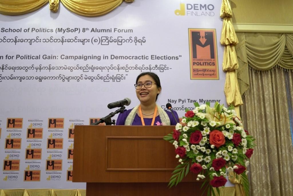 Myanmarilainen nainen puhuu mikrofoniin puhujapöntössä