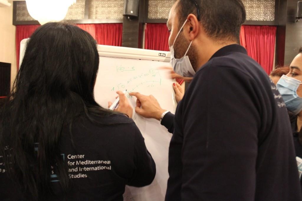 Two people writing on a flipchart