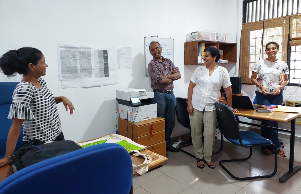 Four people looking happy in an office
