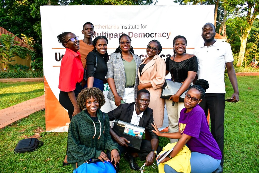 Group of Ugandan young adults outside in front of a wall