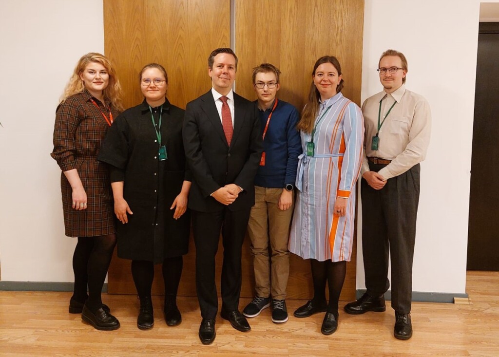 Five young adults and between them a man in a black suit