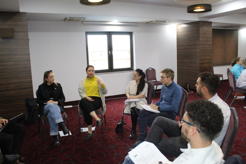 People sitting in a circle, one of them speaks and the others are listening