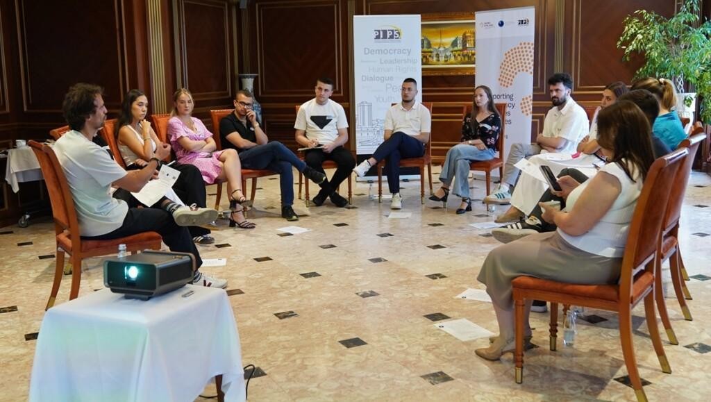 Young people sitting on chairs in a circle.